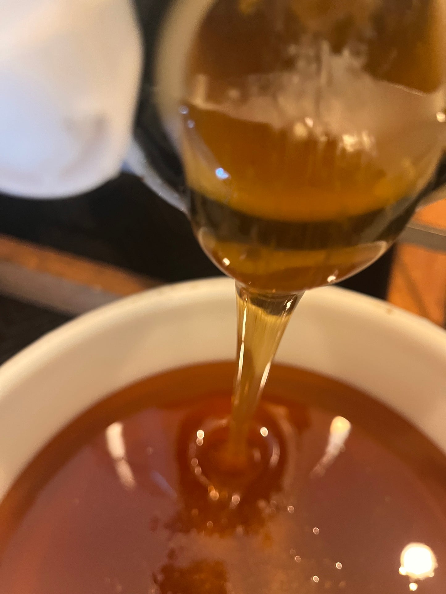 Spoon pouring honey into a bowl
