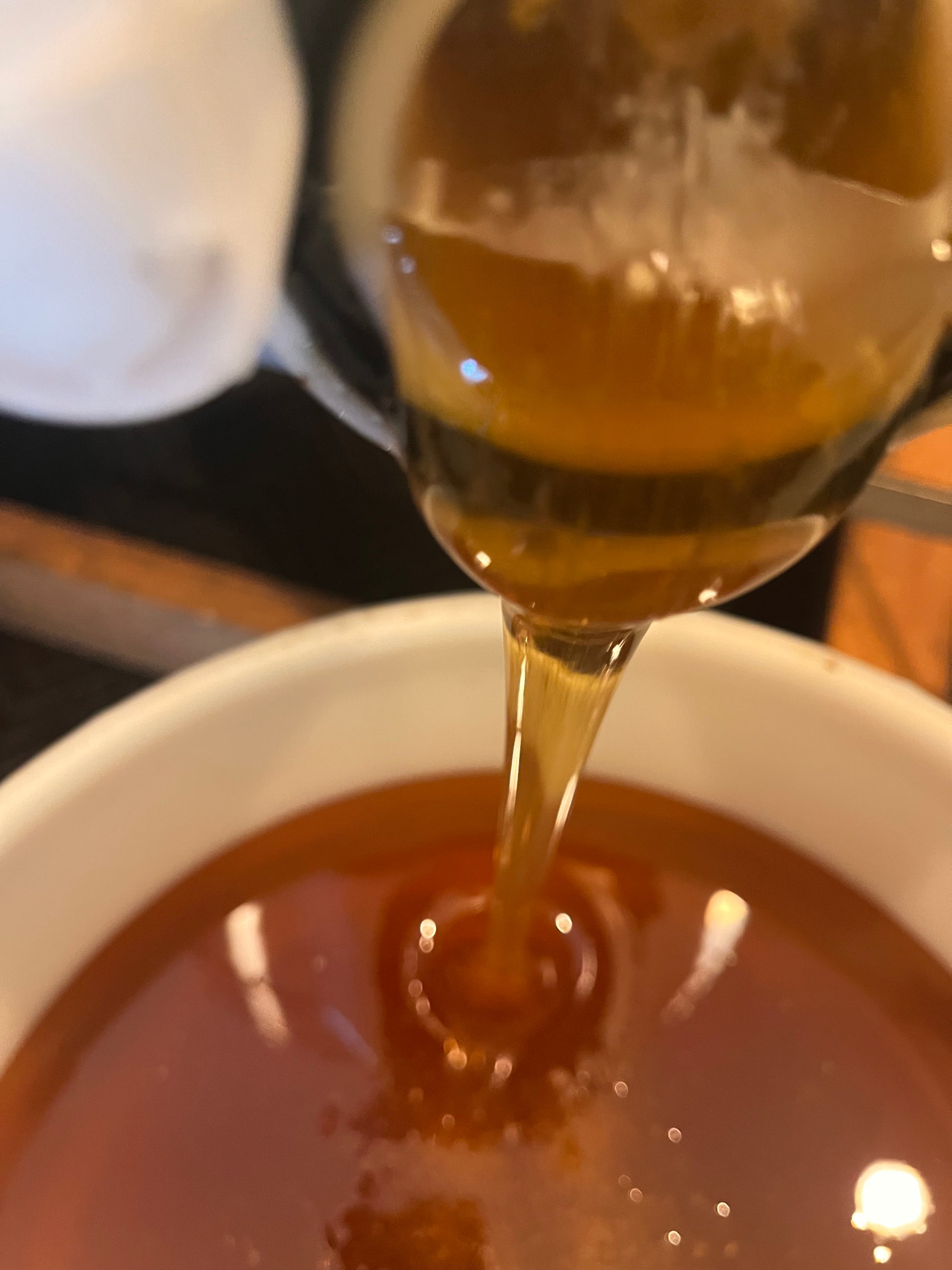 Spoon pouring honey into a bowl